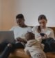 Family on a sofa using a laptop and smartphones at the same time at home