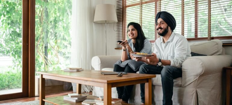 Couple watching TV channels together in their living room