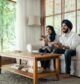Couple watching TV channels together in their living room